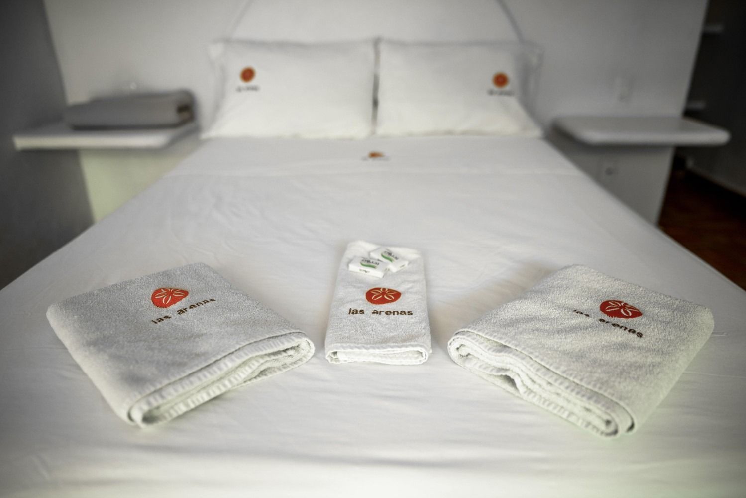 A bed with three towels on it in a hotel room.