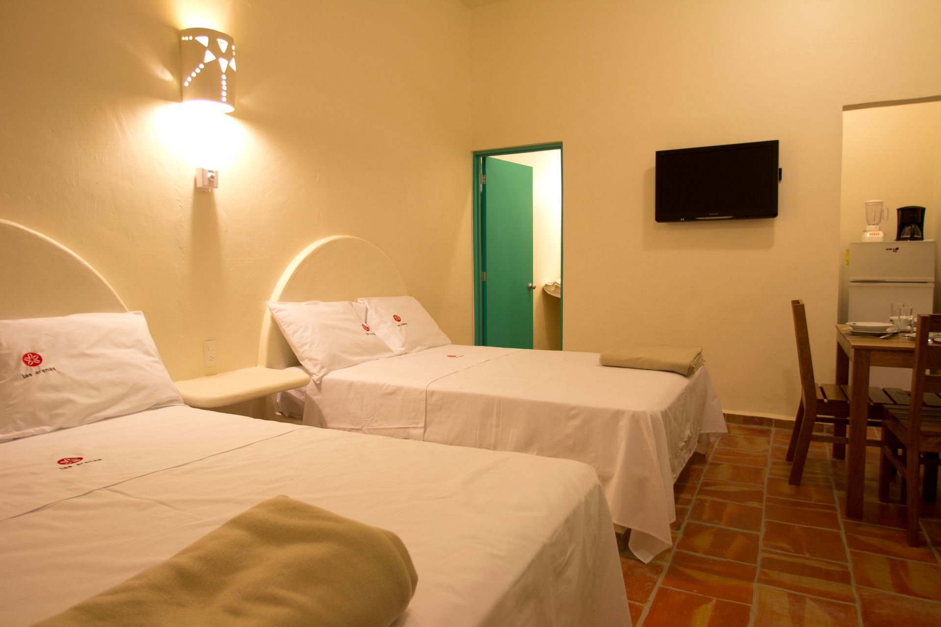 A hotel room with two beds and a flat screen tv.