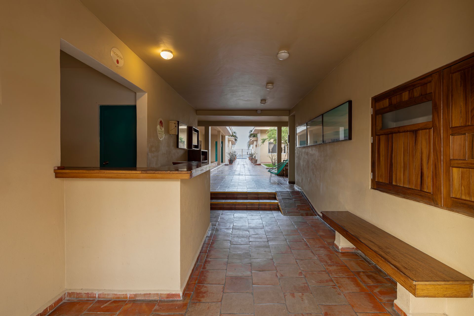 A long hallway with a bench and a counter in a building.