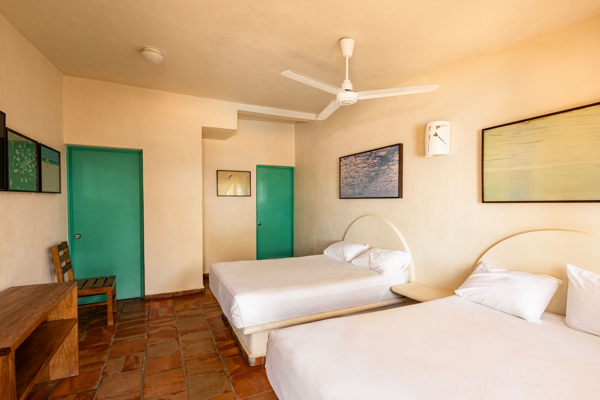 A hotel room with two beds and a ceiling fan.