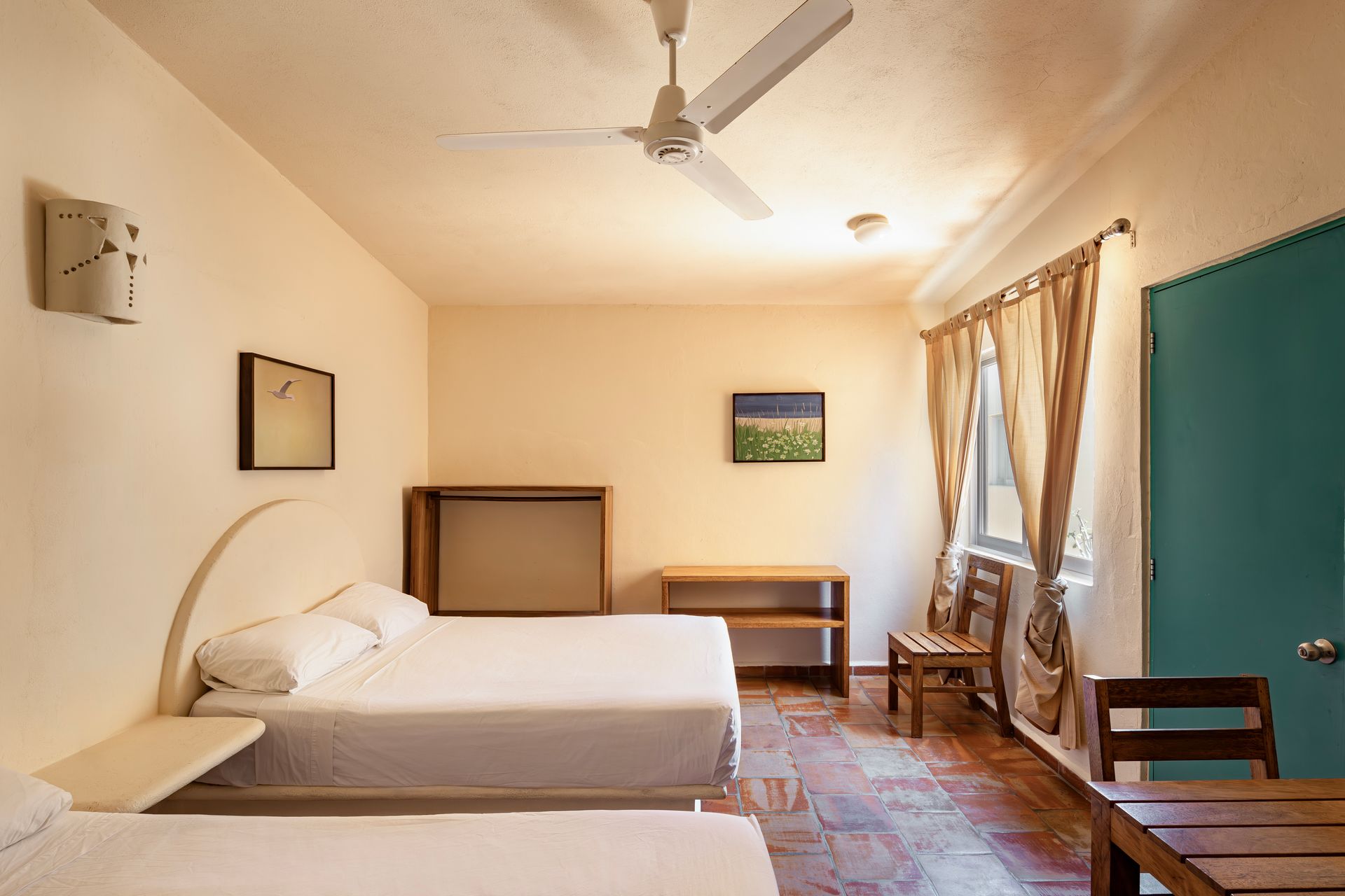 A hotel room with two beds and a ceiling fan