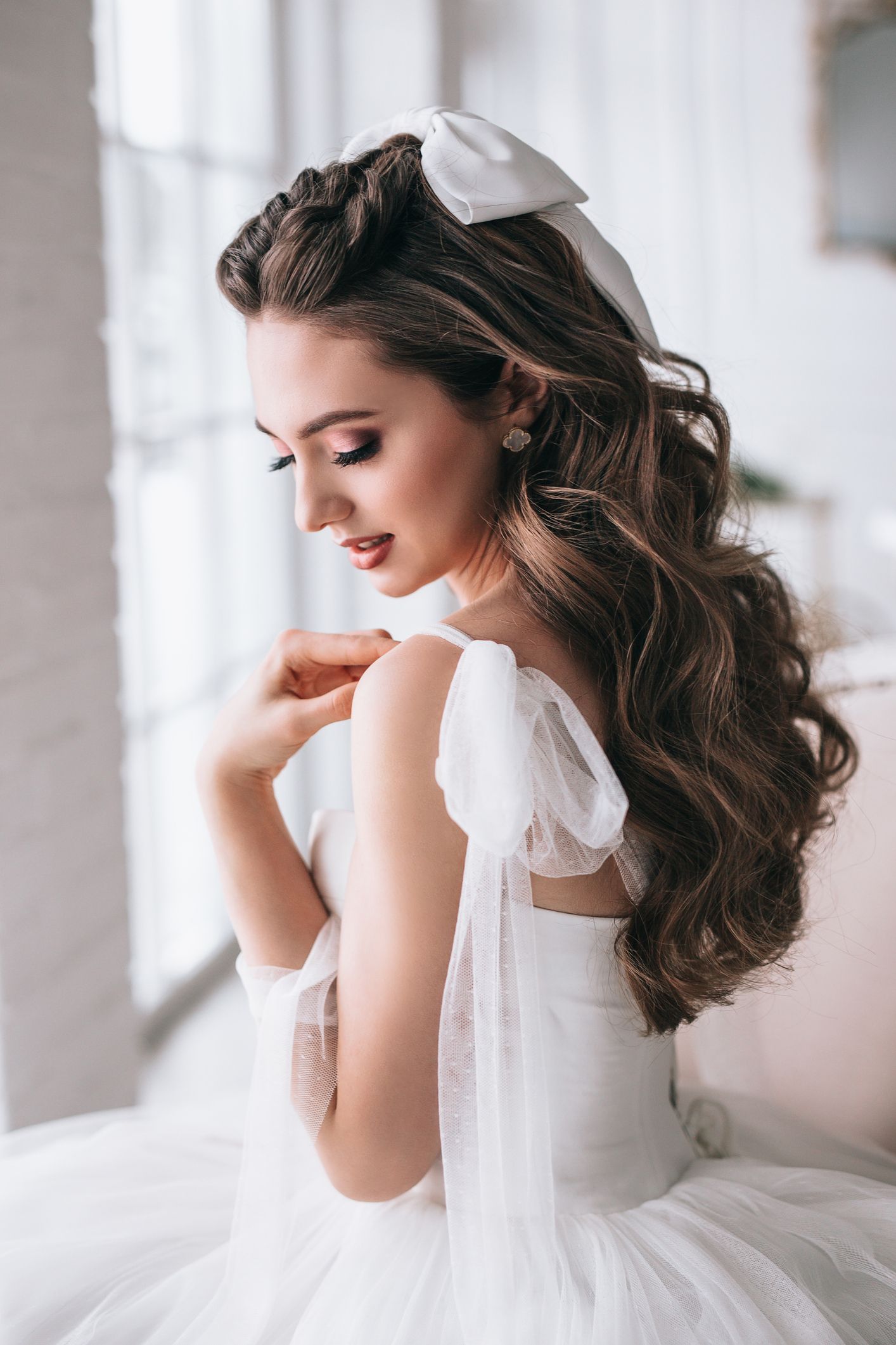 A woman in a wedding dress is sitting on a couch.