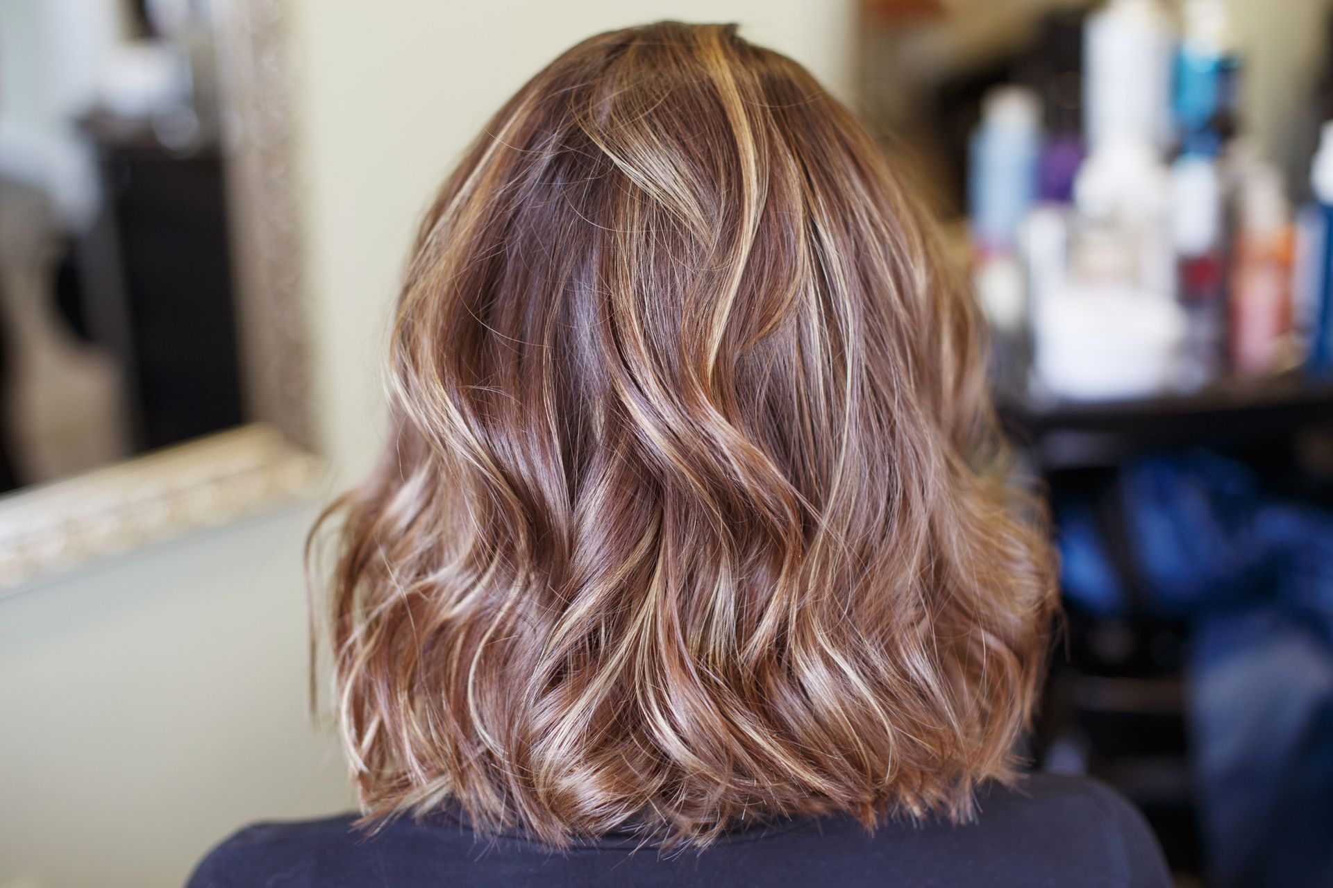 The back of a woman 's hair is shown in a salon.