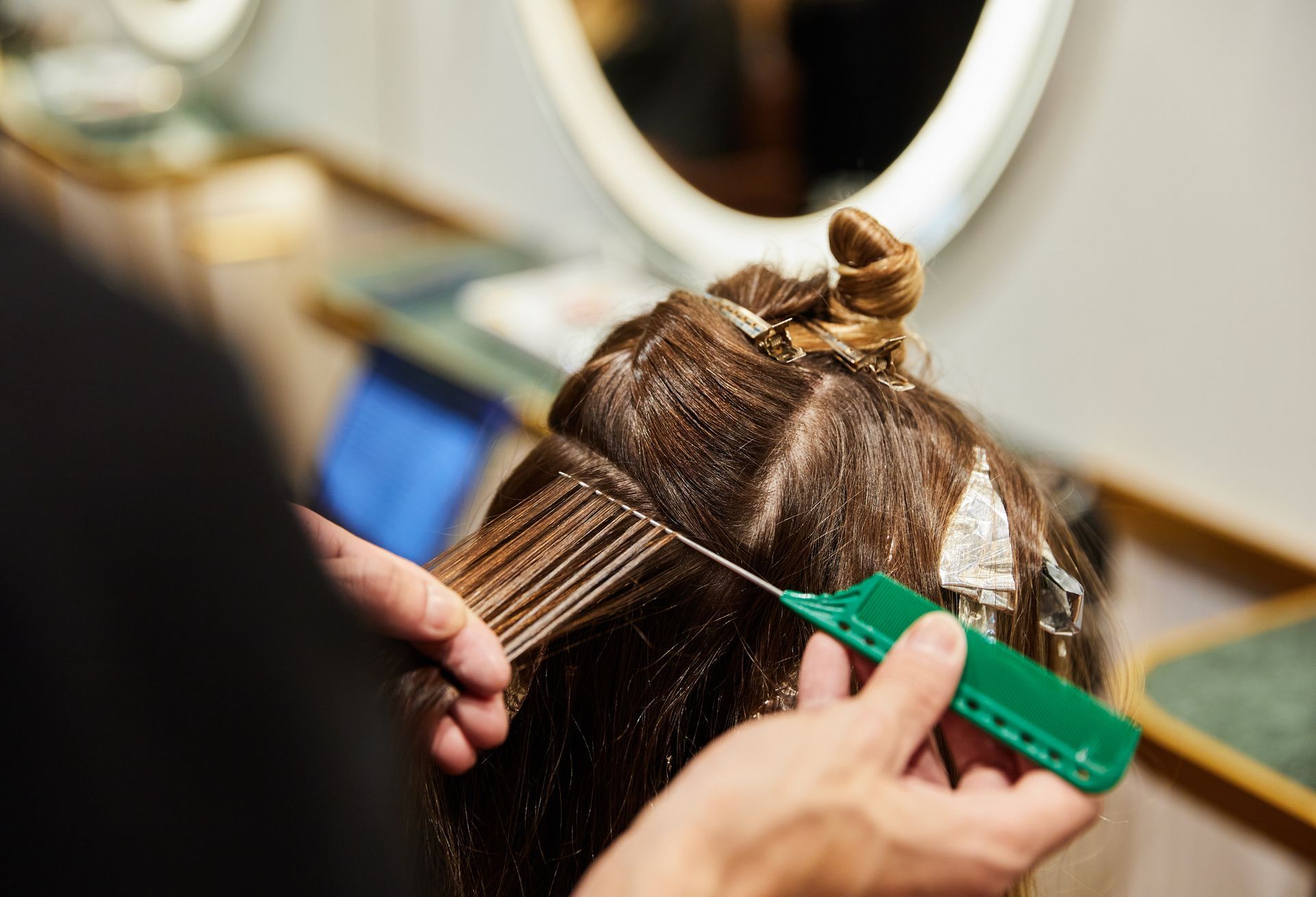 A woman is getting her hair dyed by a hairdresser.