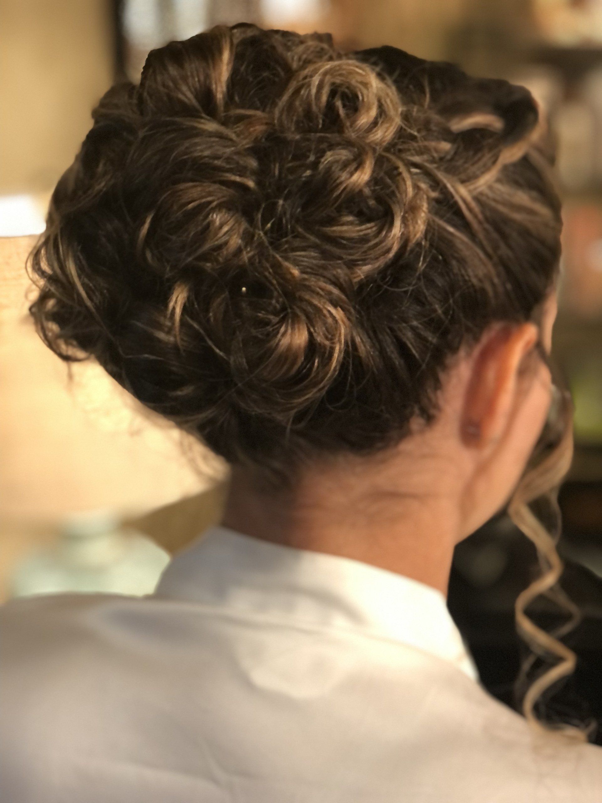 A woman is wearing a white robe and has her hair in a bun