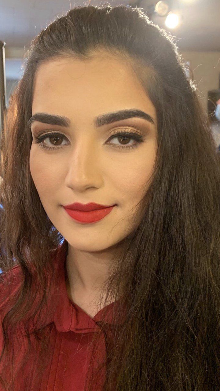 A close up of a woman wearing red lipstick and a red shirt.
