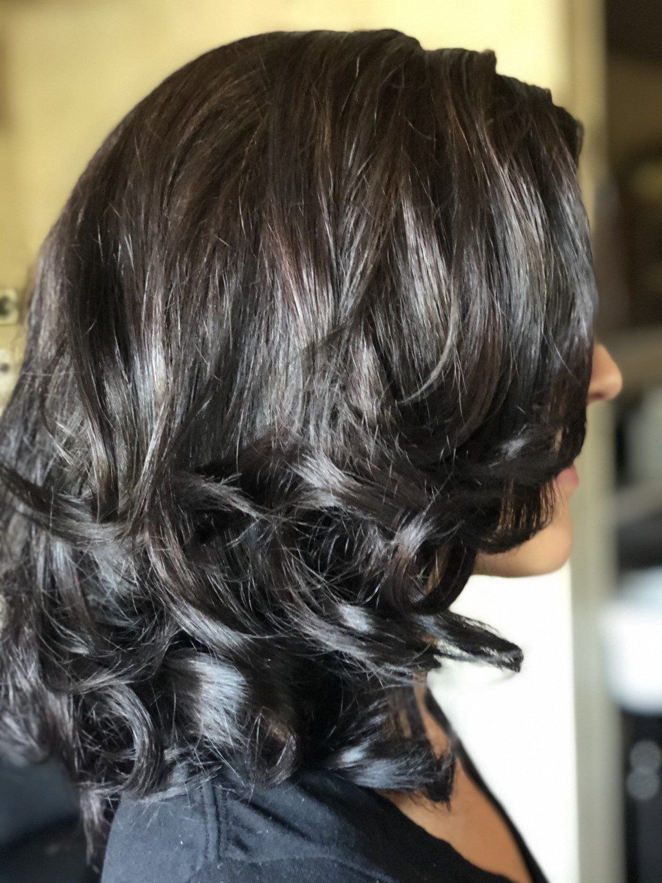 A woman with long dark hair is wearing a black shirt.