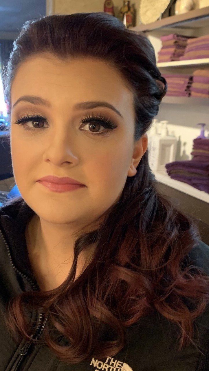 A woman wearing a black north face jacket is looking at the camera.