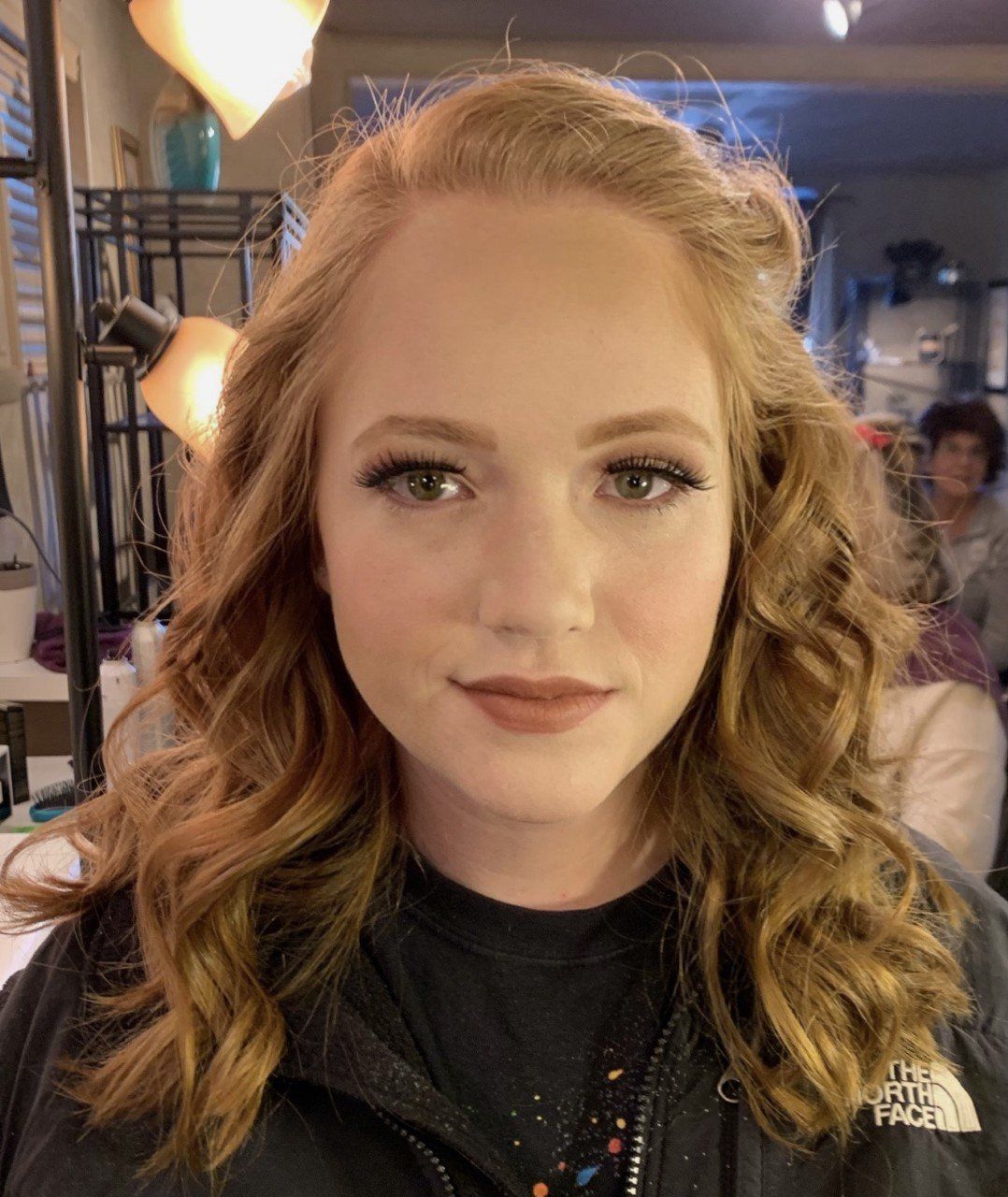 A woman wearing a black north face jacket looks at the camera