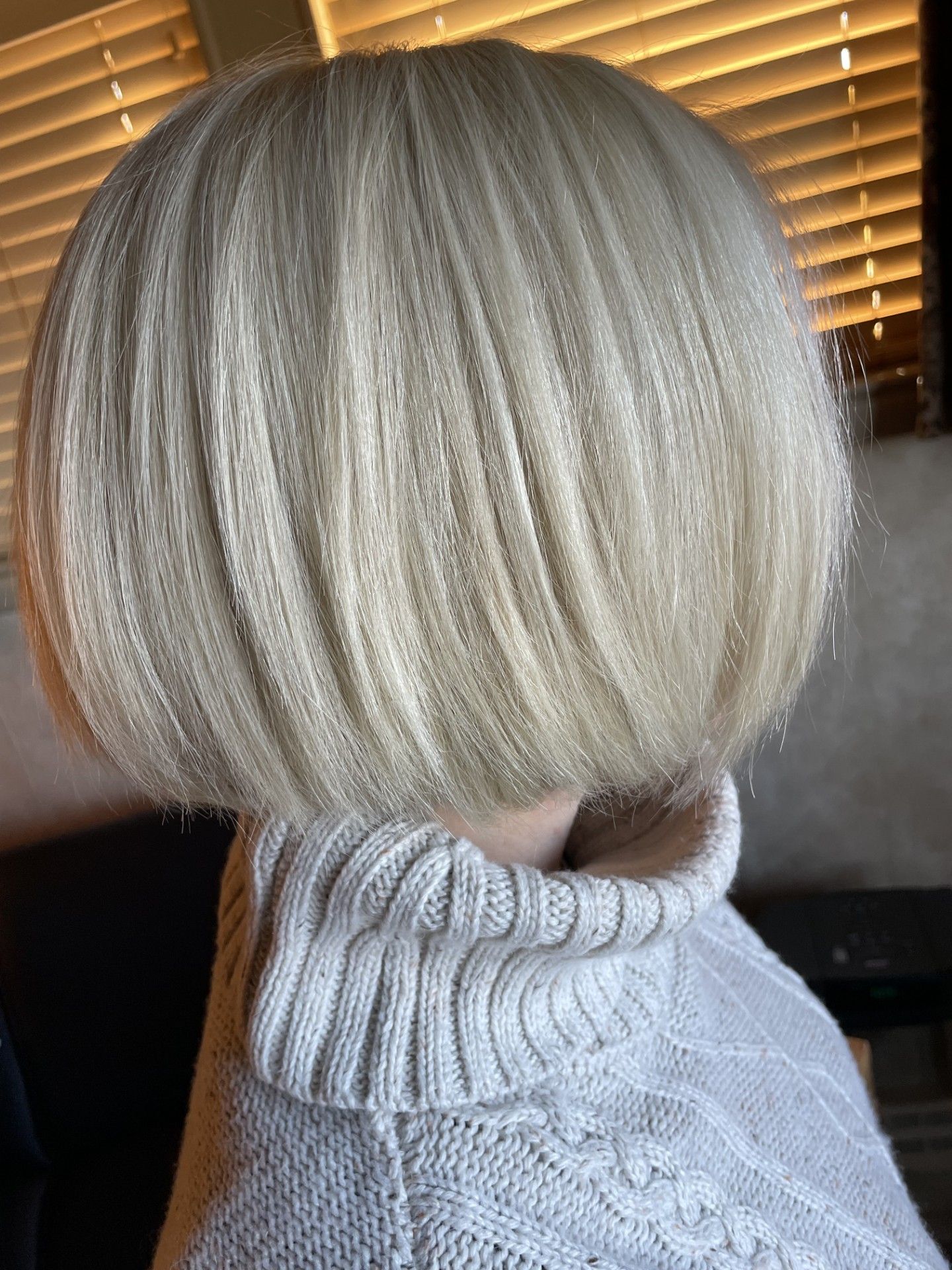 A Woman with Blonde Hair Is Wearing a White Sweater.