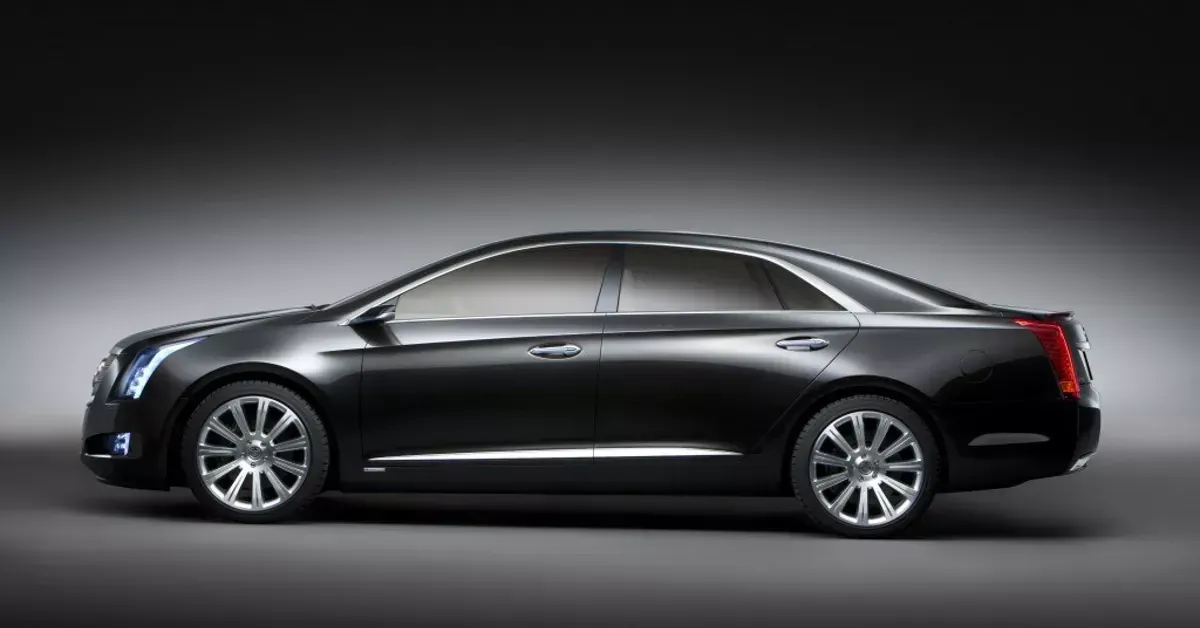 A black cadillac is parked in a dark room