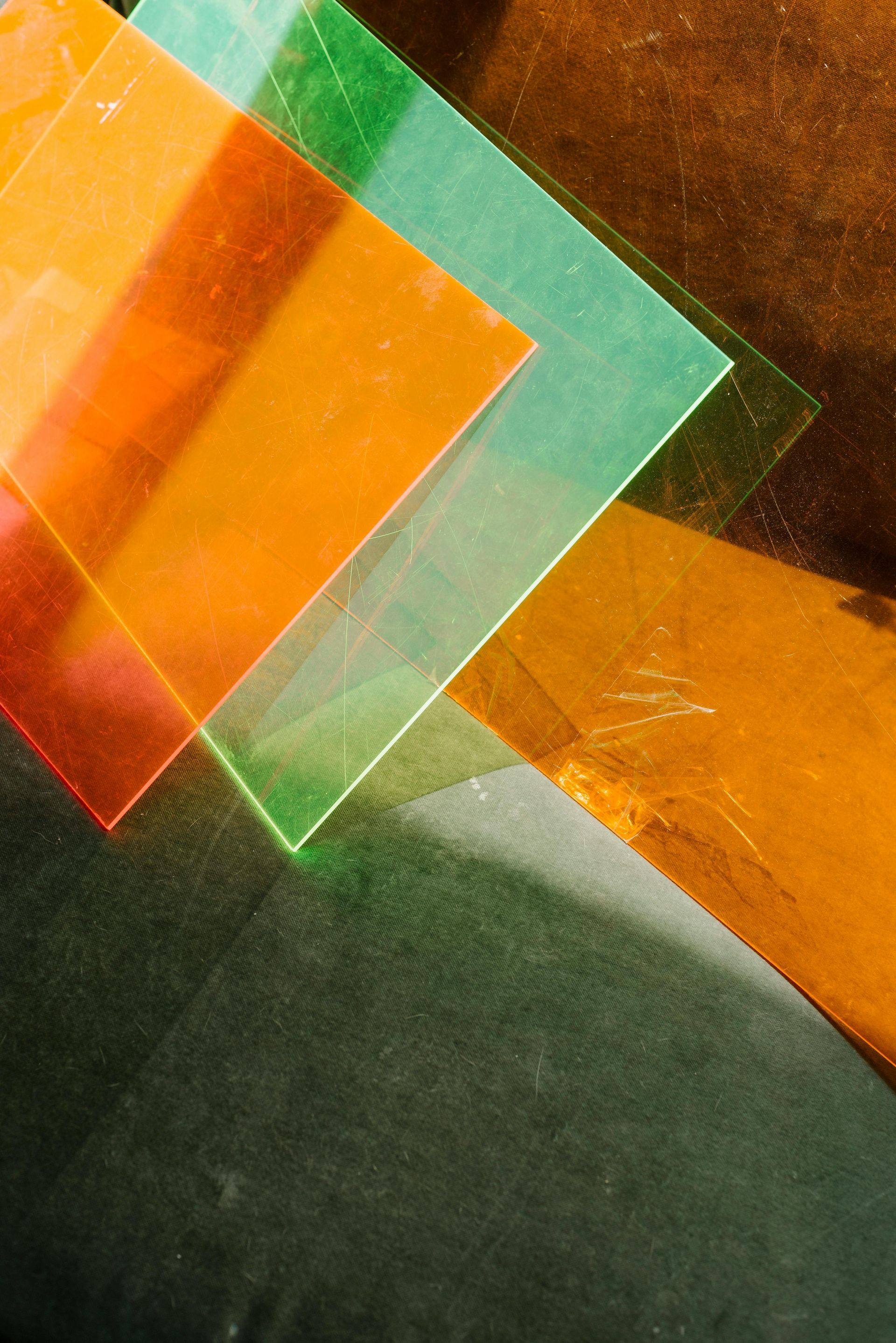 A close up of a stack of colorful plastic sheets on a table.