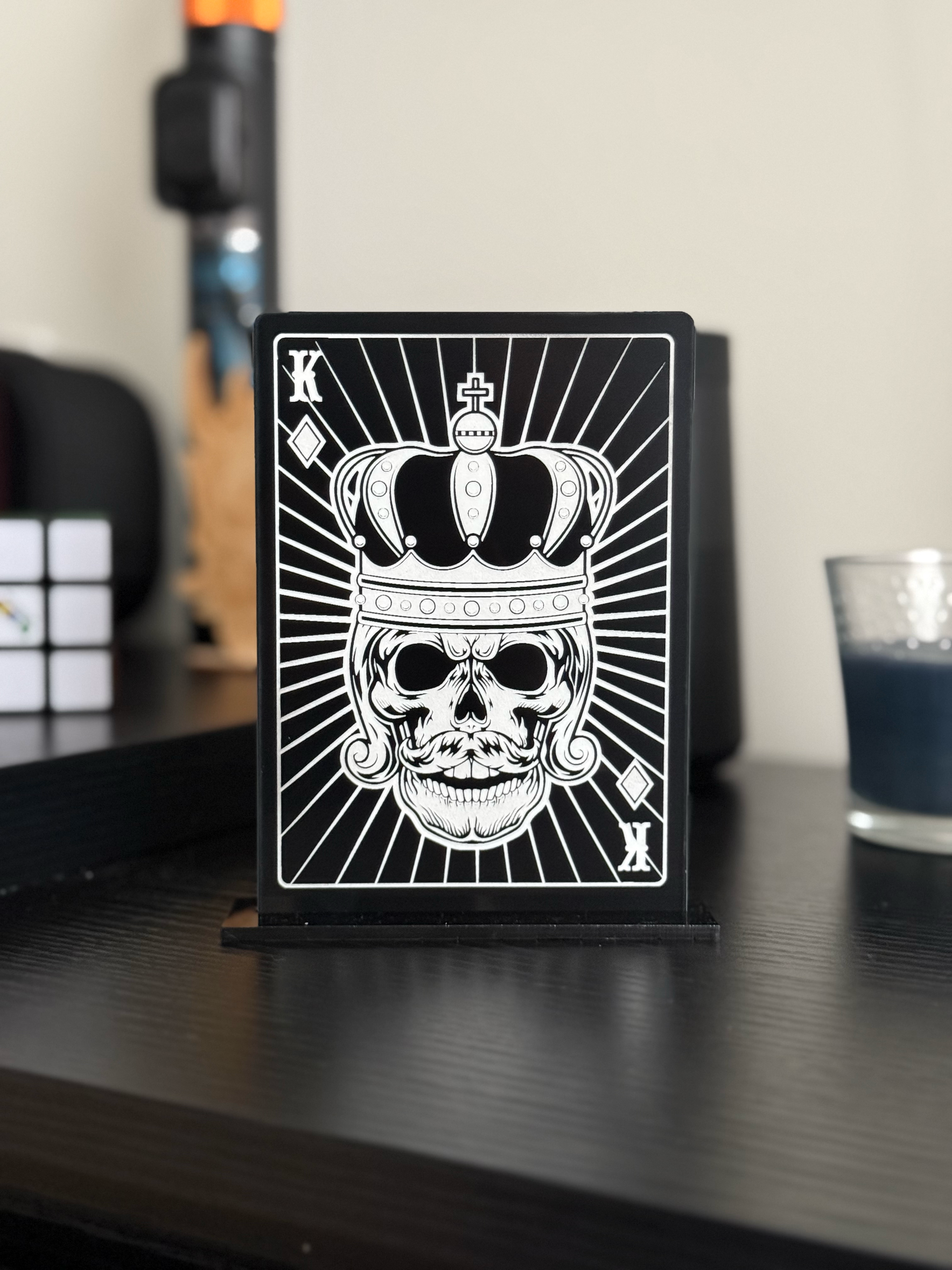 A black and white picture of a skull wearing a crown on a table.