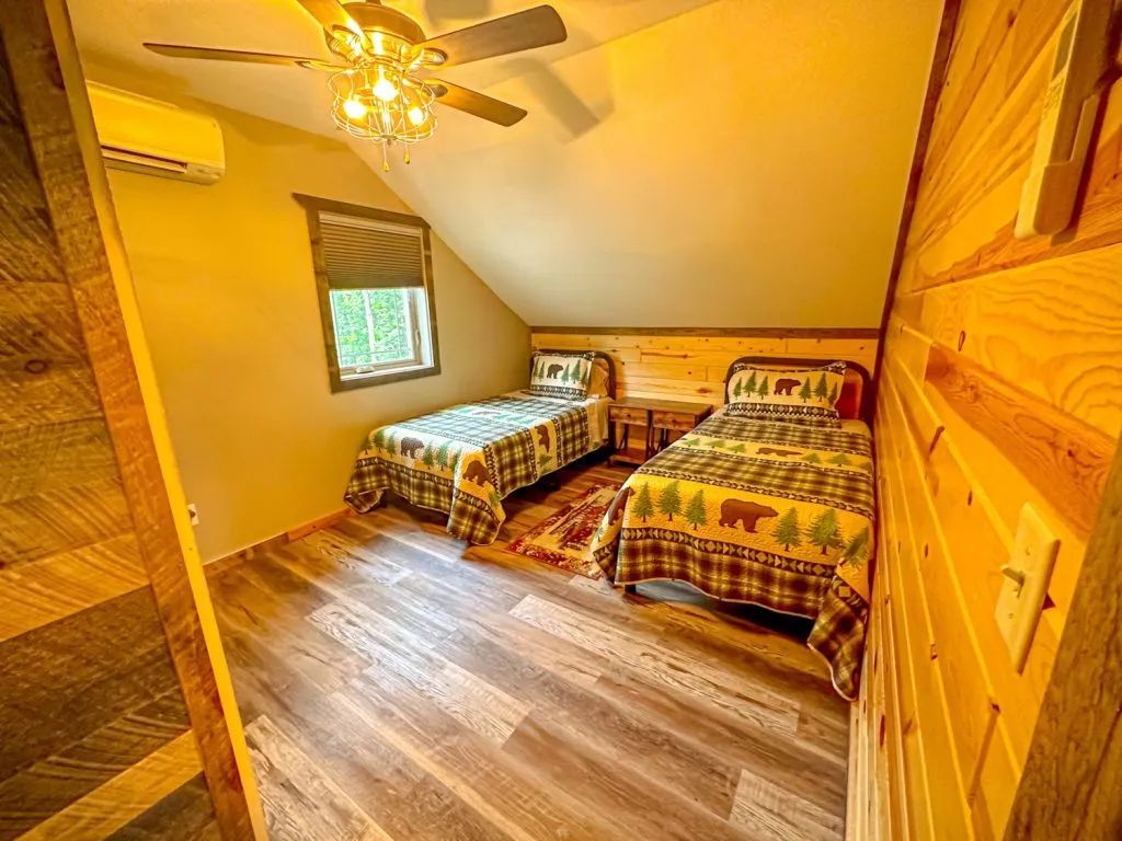 A bedroom with two twin beds and a ceiling fan.