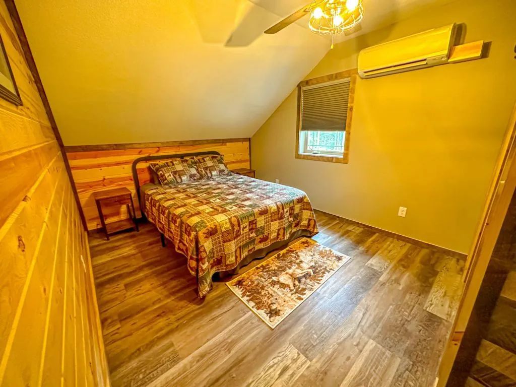 A bedroom with a bed and a ceiling fan.