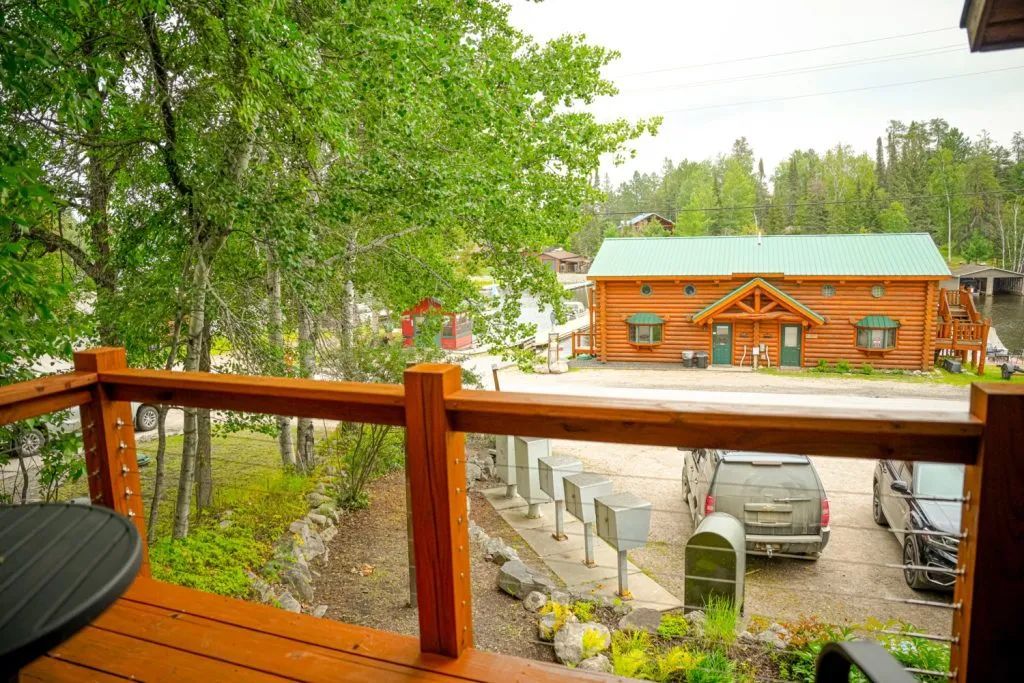 A view of a log cabin from a deck with a table and chairs.