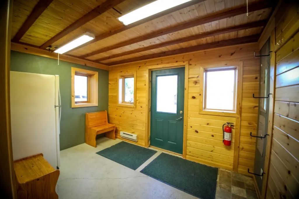 A room with a green door and a fire extinguisher on the wall