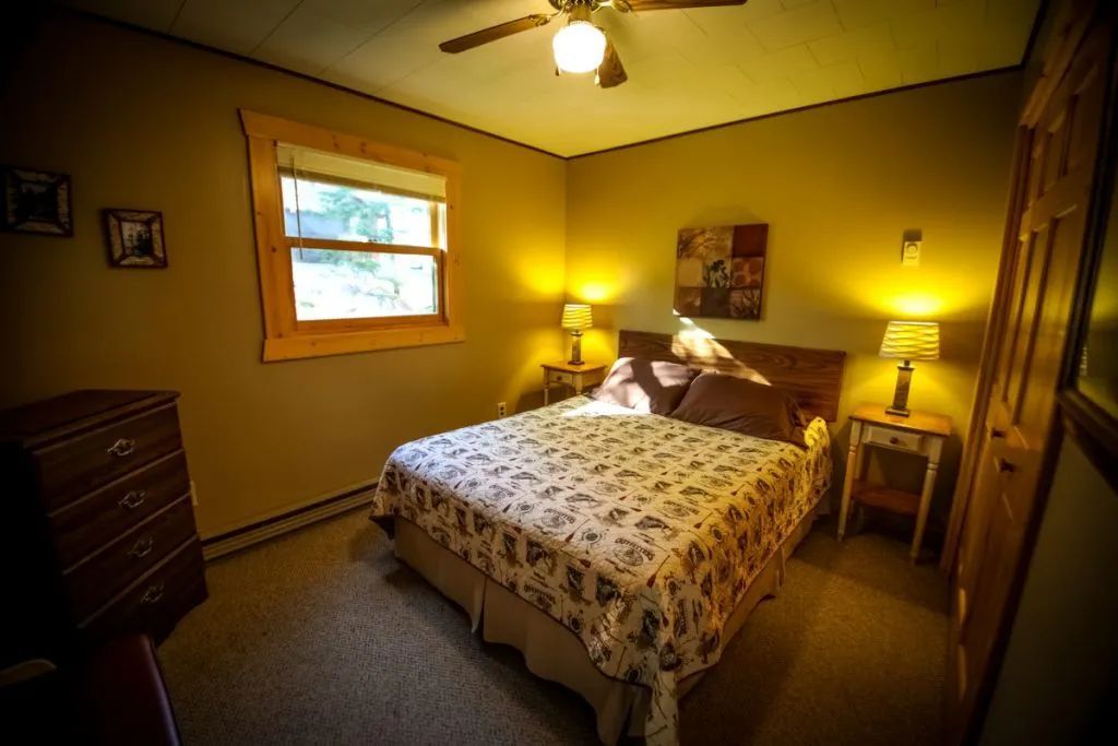 A bedroom with a king size bed and a ceiling fan.