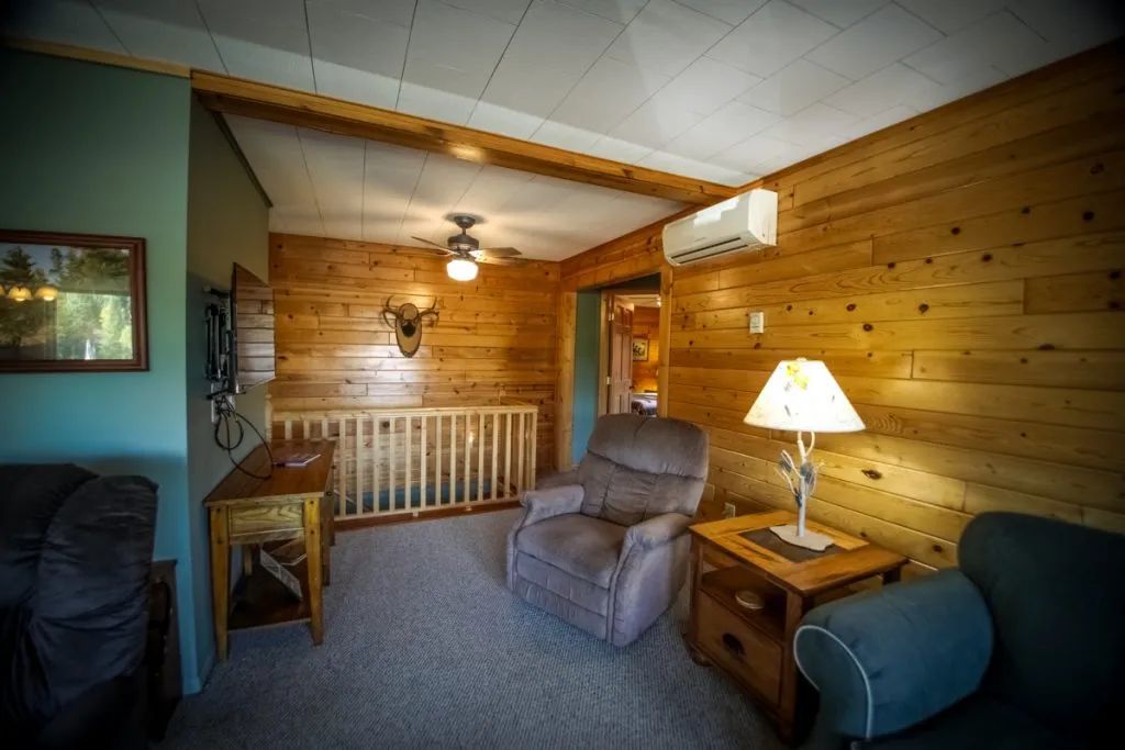A living room with a couch , chair , table and lamp.