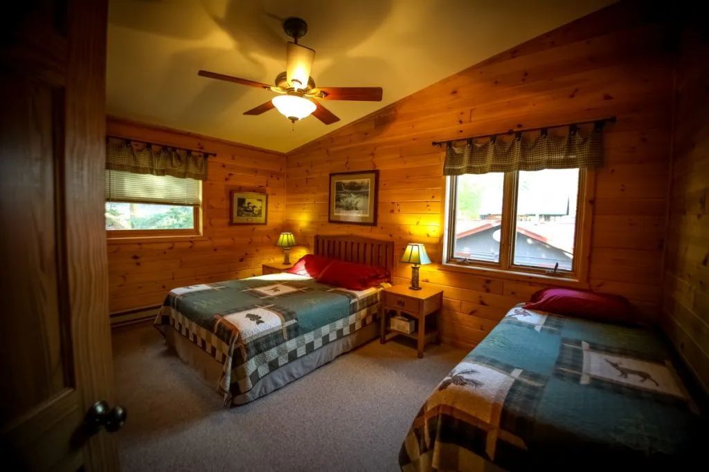 A bedroom with two beds and a ceiling fan