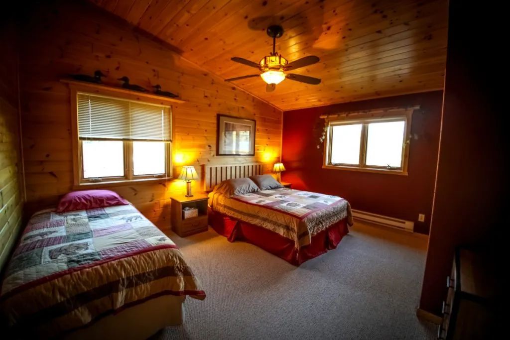A bedroom with two beds and a ceiling fan.