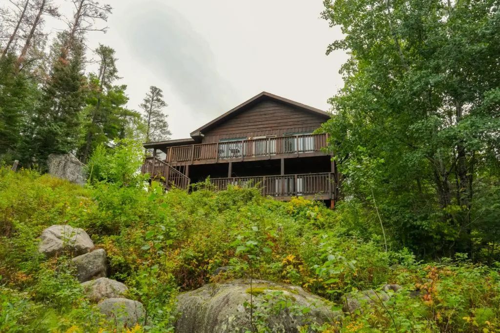 A large house is sitting on top of a hill surrounded by trees.
