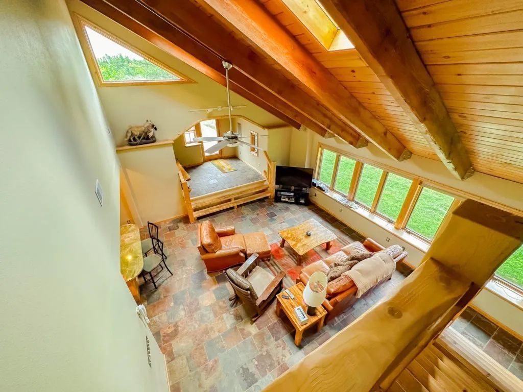 An aerial view of a living room with a lot of furniture and a wooden ceiling.