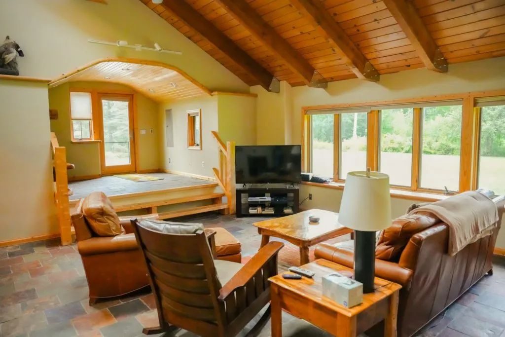 A living room with a couch , chair , table and television.