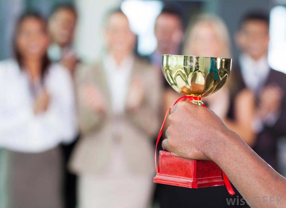 A hand holding a trophy at work