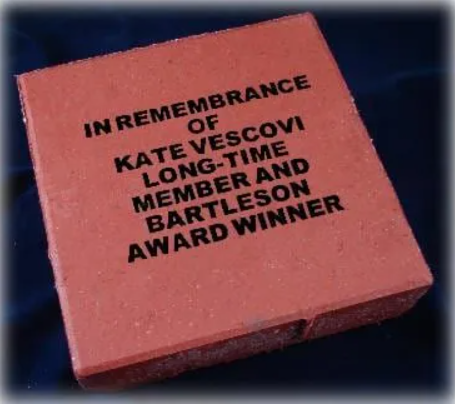 Laser cutter cutting shapes from metal sheet. Sparks fly from the cutting point in an industrial setting.