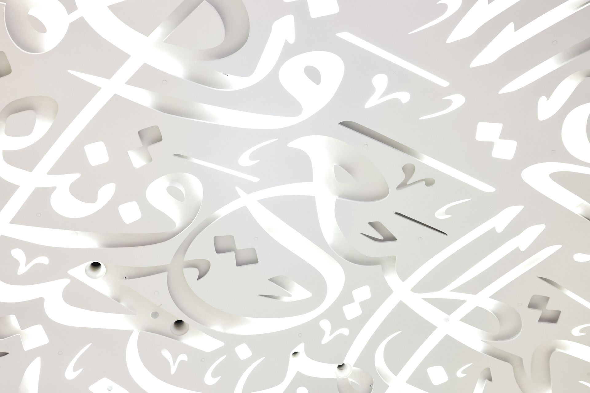 Dog tags on a ball chain, engraved with military information, lying against a cork background.