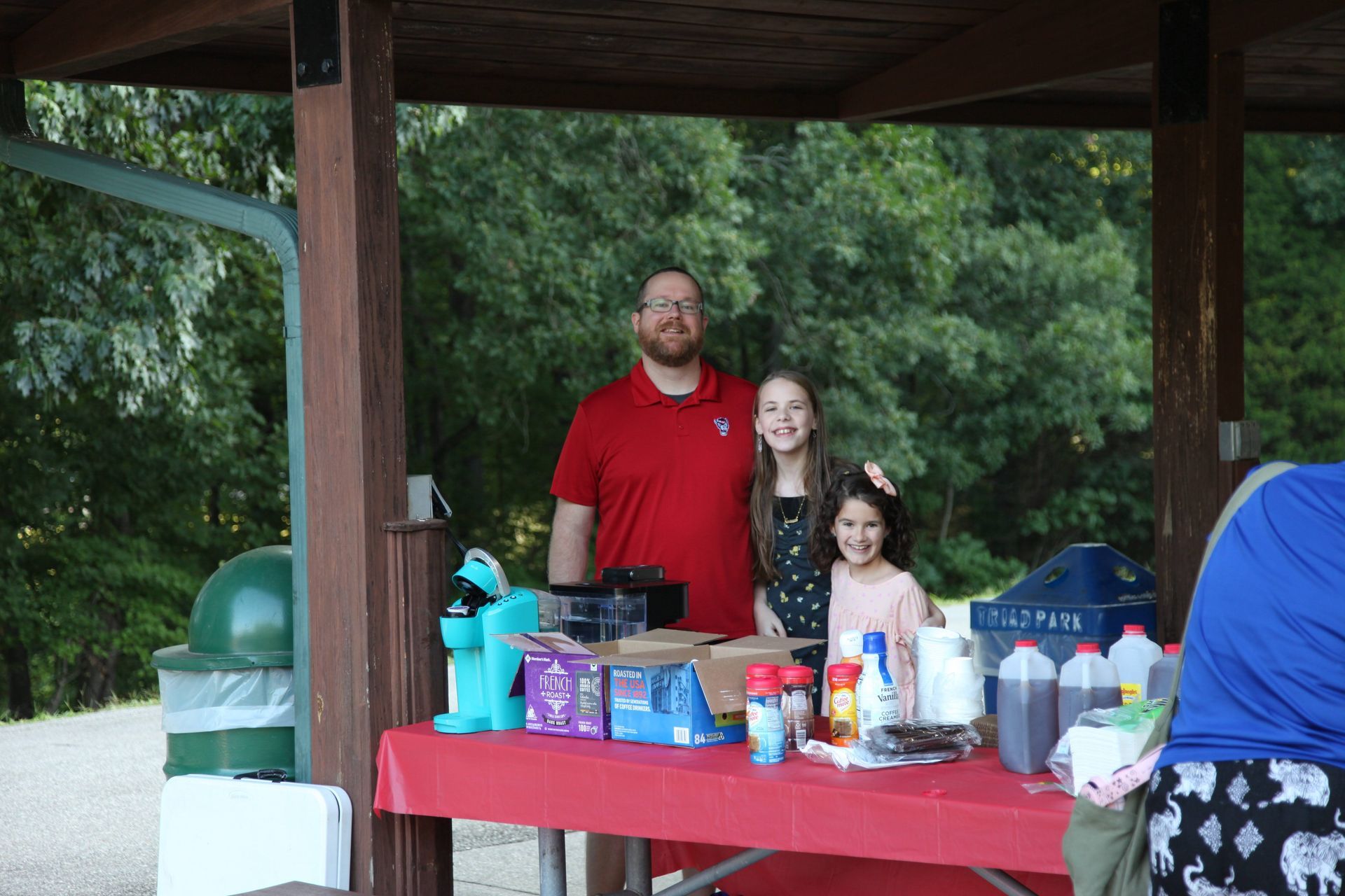A man and two children are standing in front of a table.