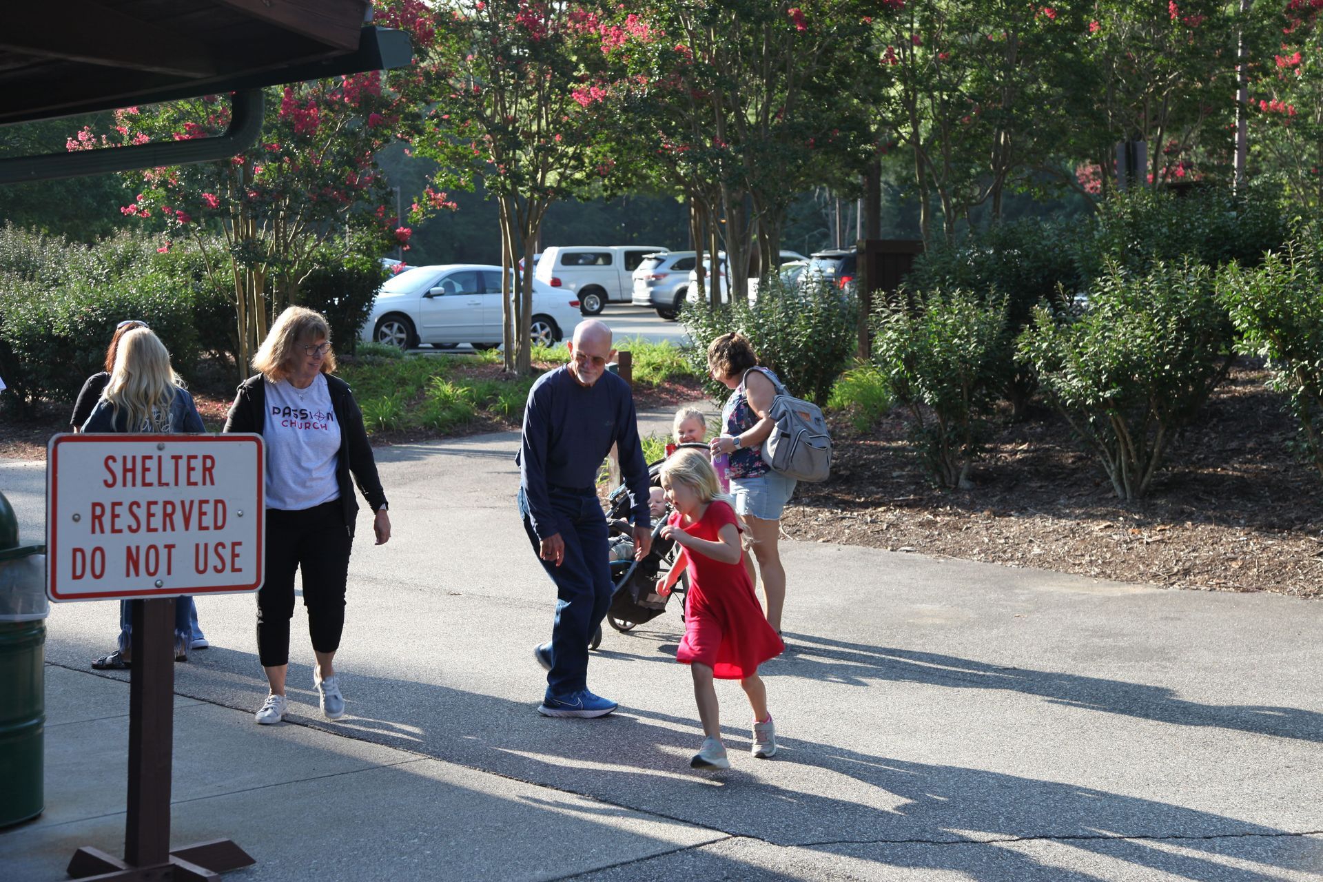A group of people walking past a sign that says shelter reserved do not use