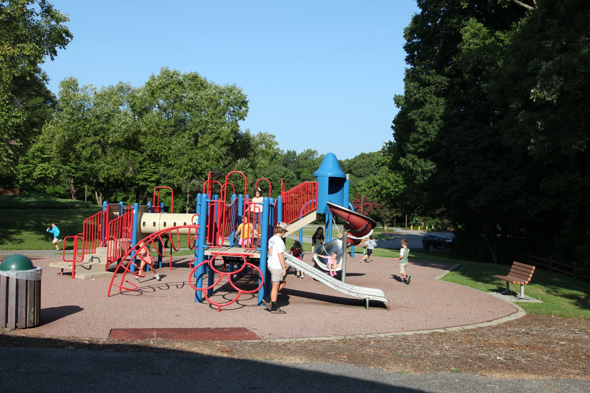 A group of children are playing in a playground in a park