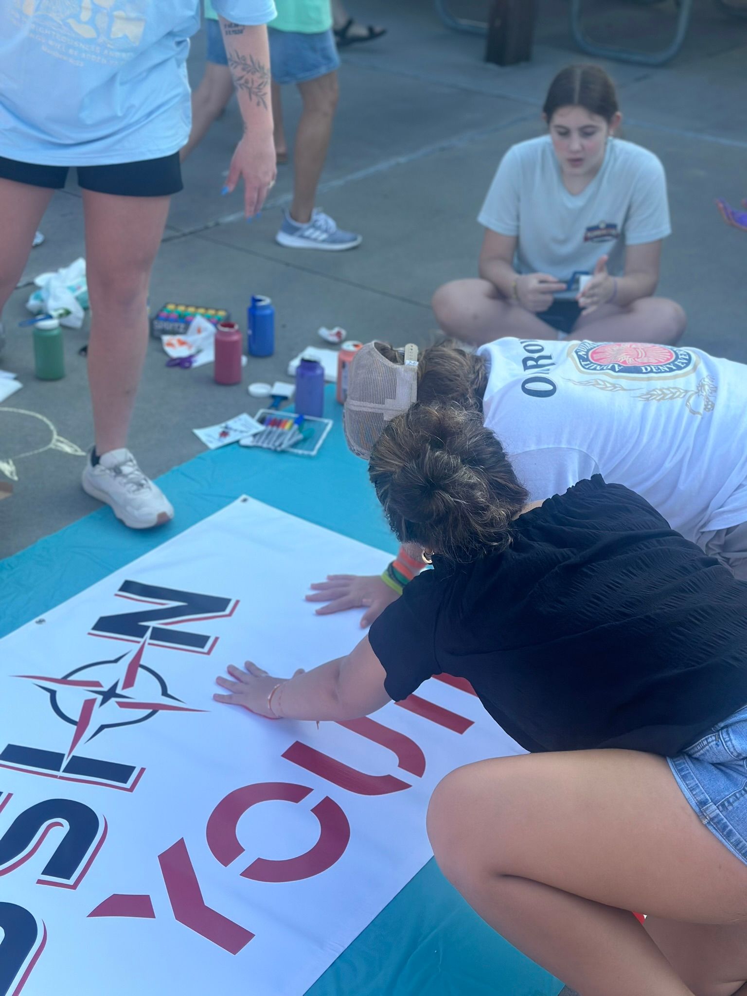 A group of people are painting a sign that says texas revolution.