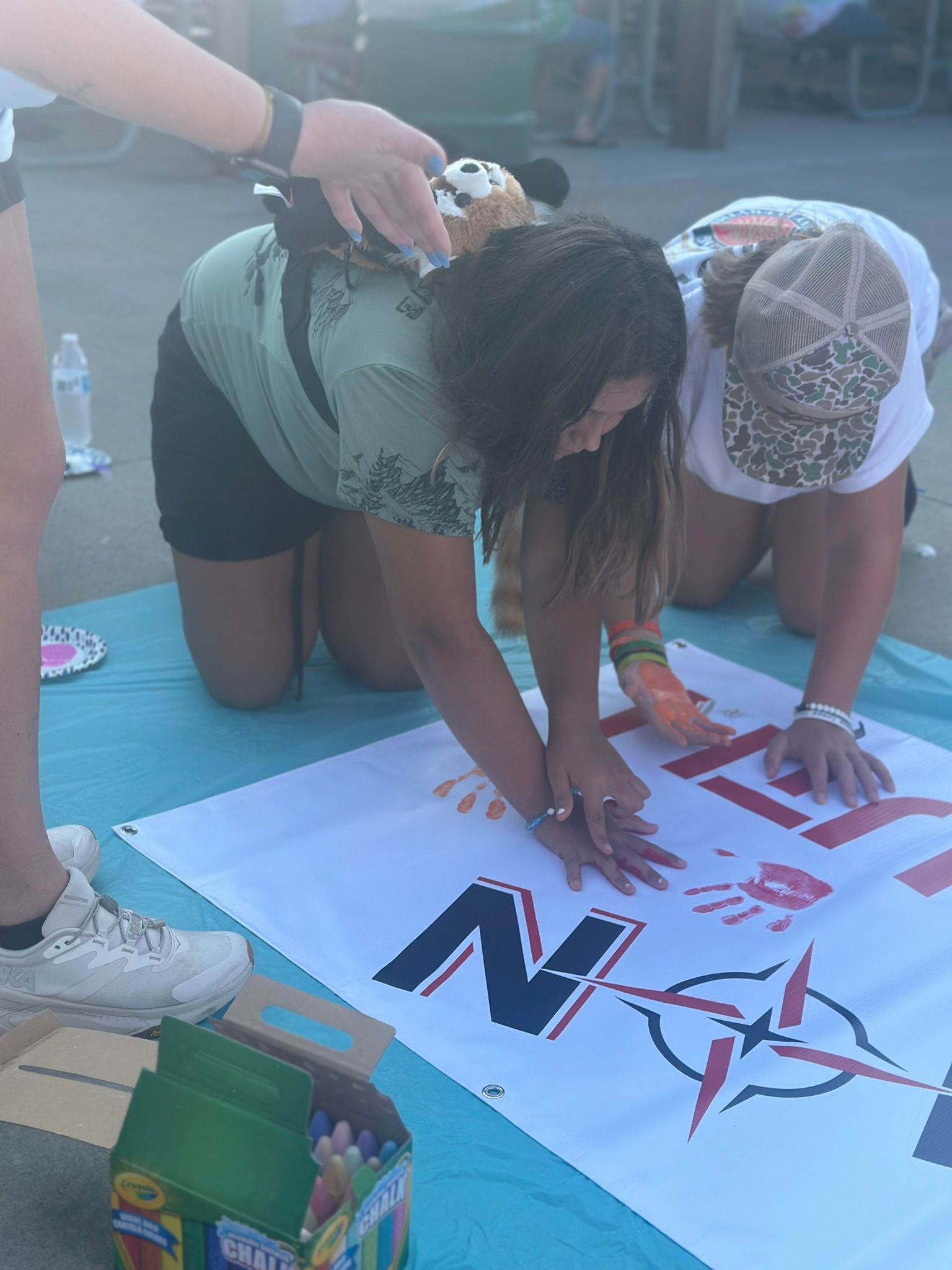 Two young girls are posing for a picture in front of a blackboard.