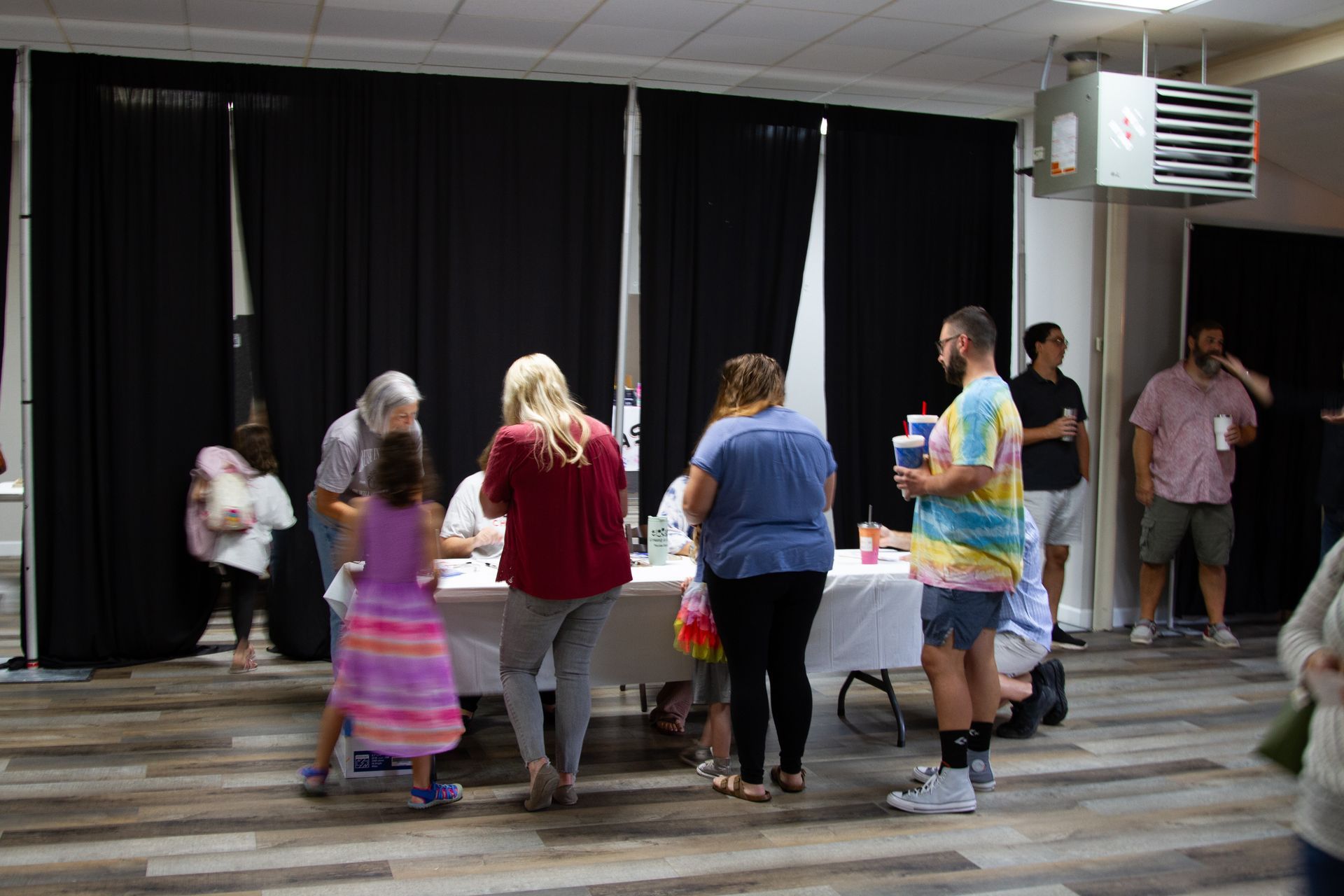 A group of people are standing around a table in a room.