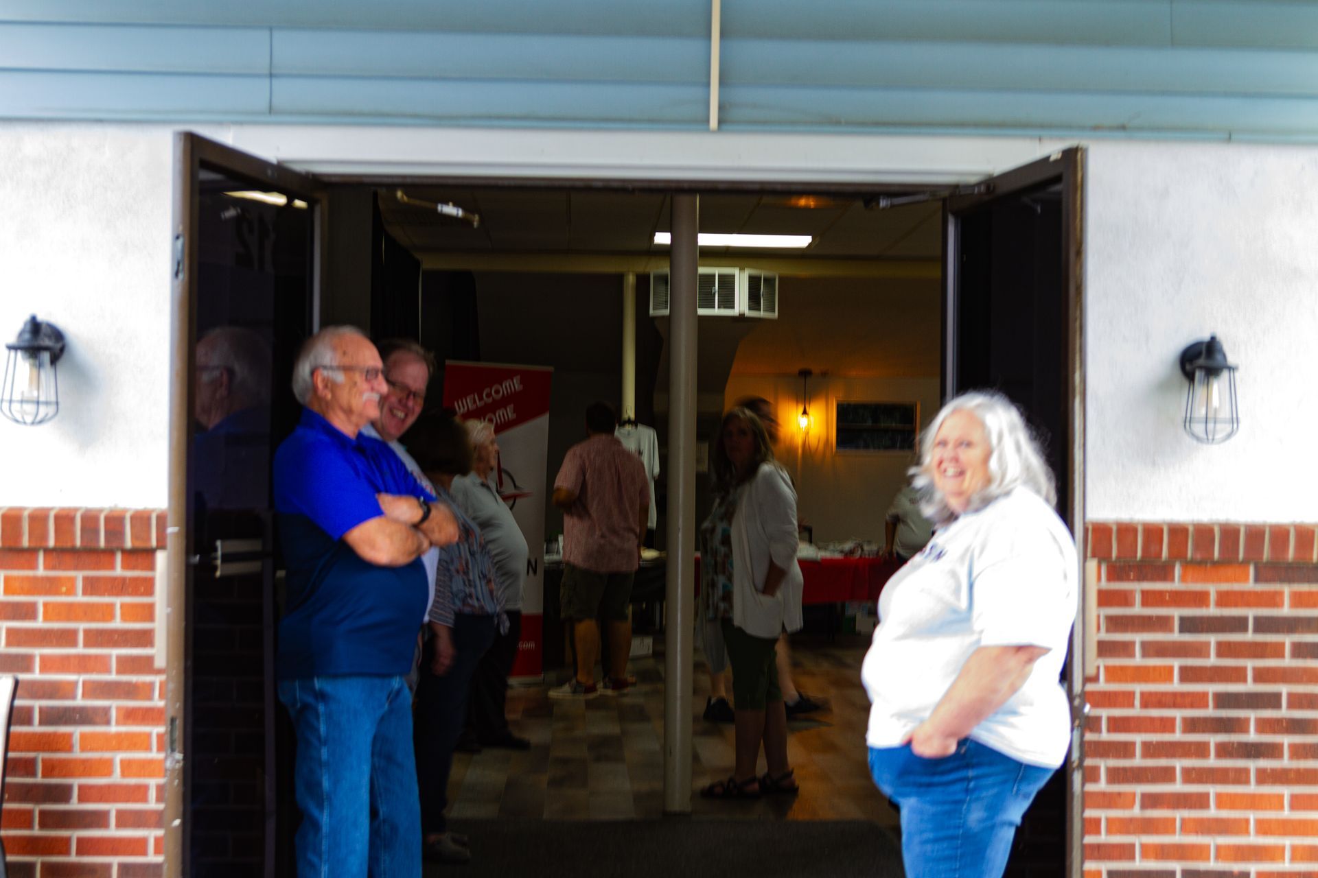 A man and a woman are standing in front of a brick building.