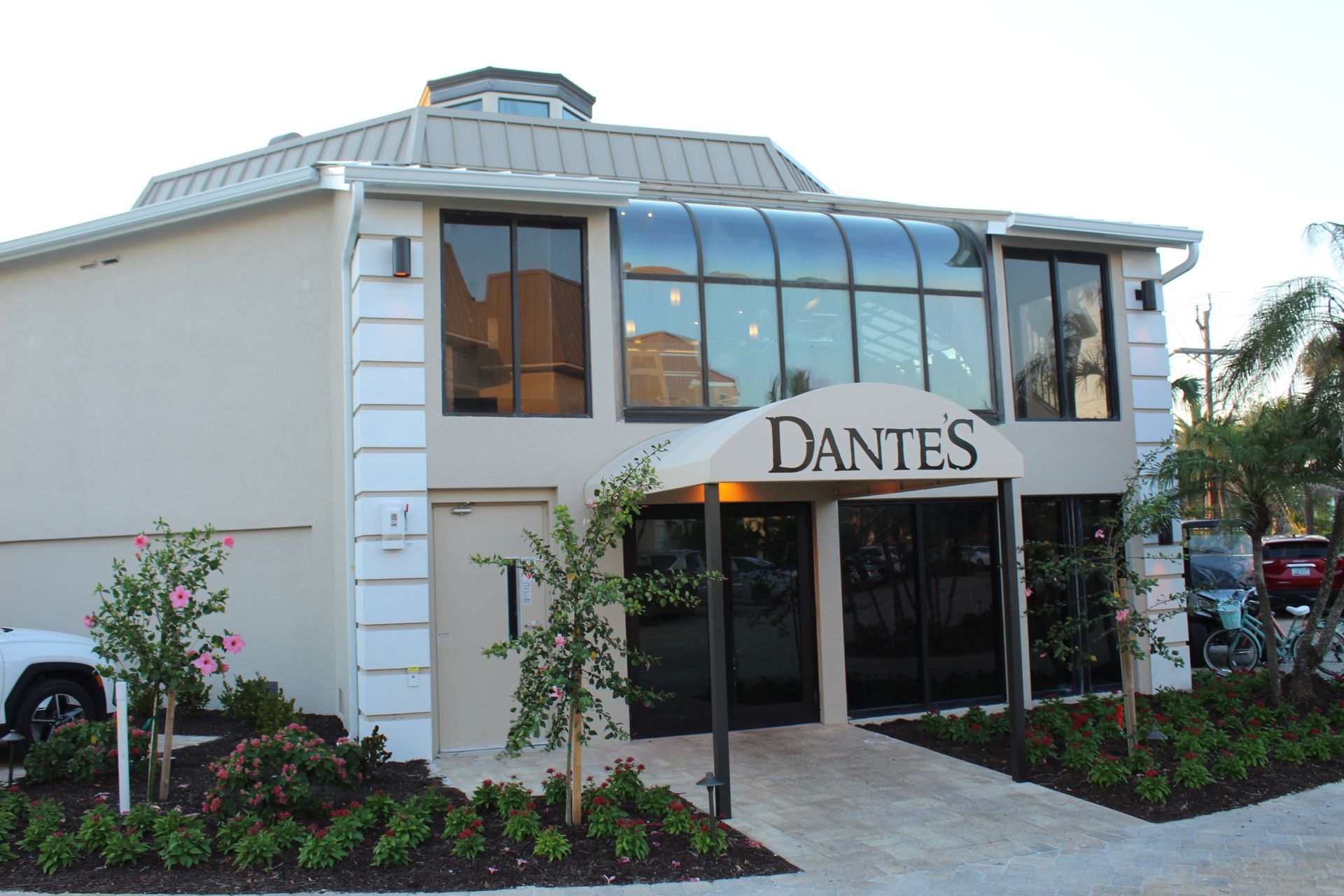 A white building with a sign that says dantes