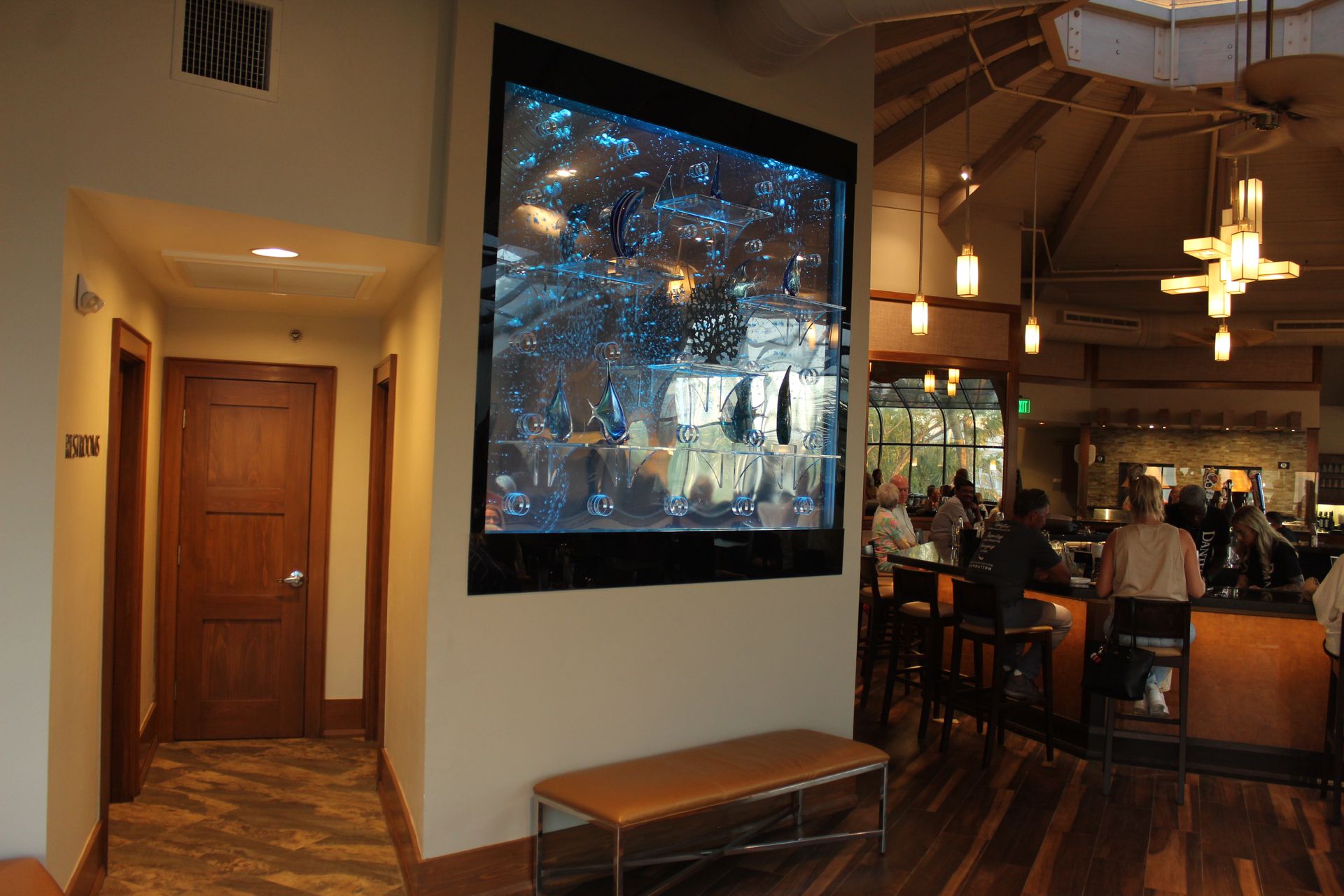 A large flat screen tv is mounted on a wall in a restaurant