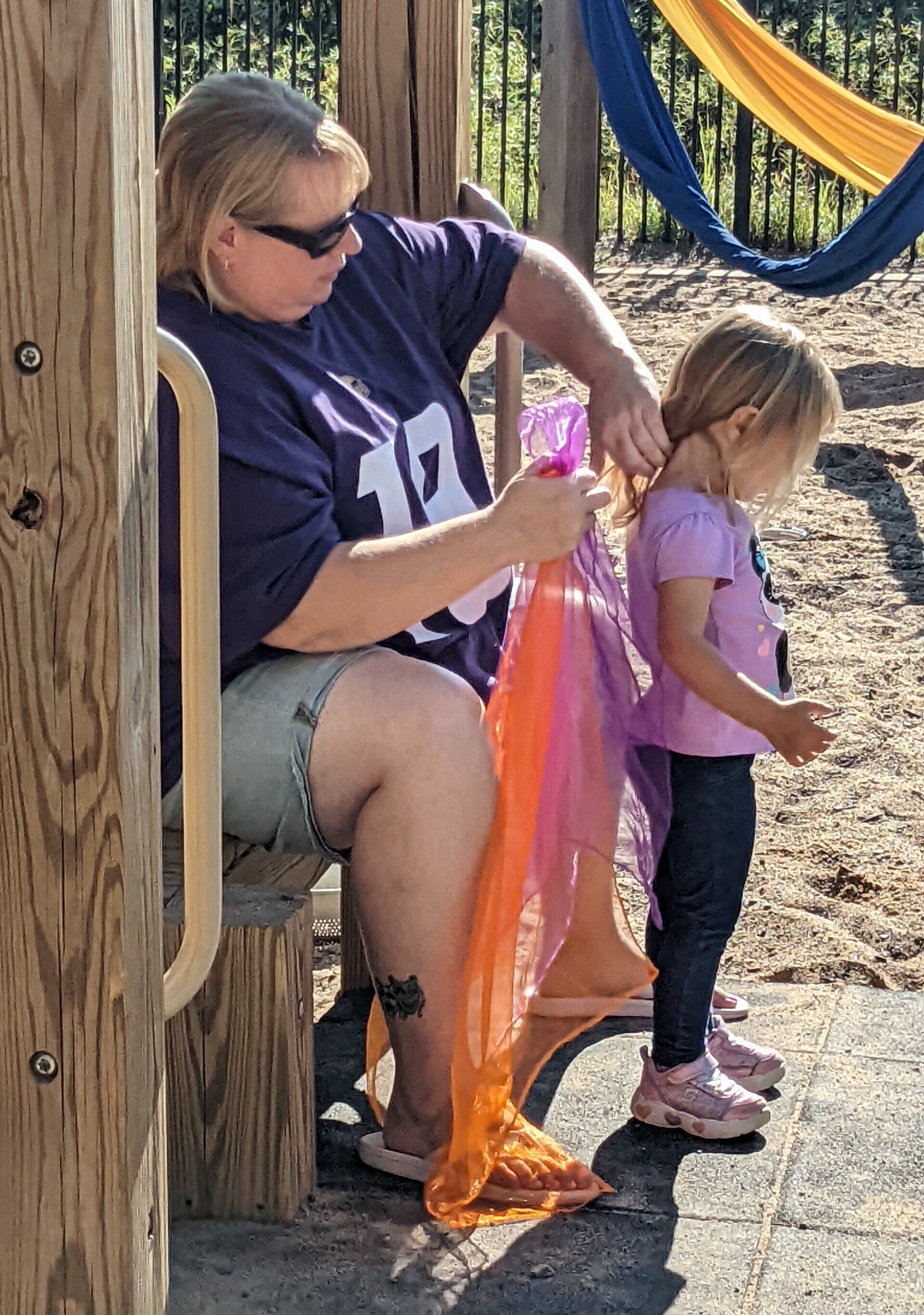 A woman is sitting next to a little girl 