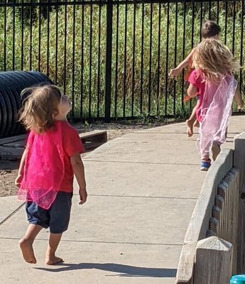 A group of children are playing on a sidewalk