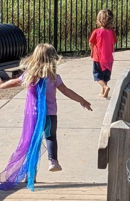 A boy and a girl are walking down a sidewalk