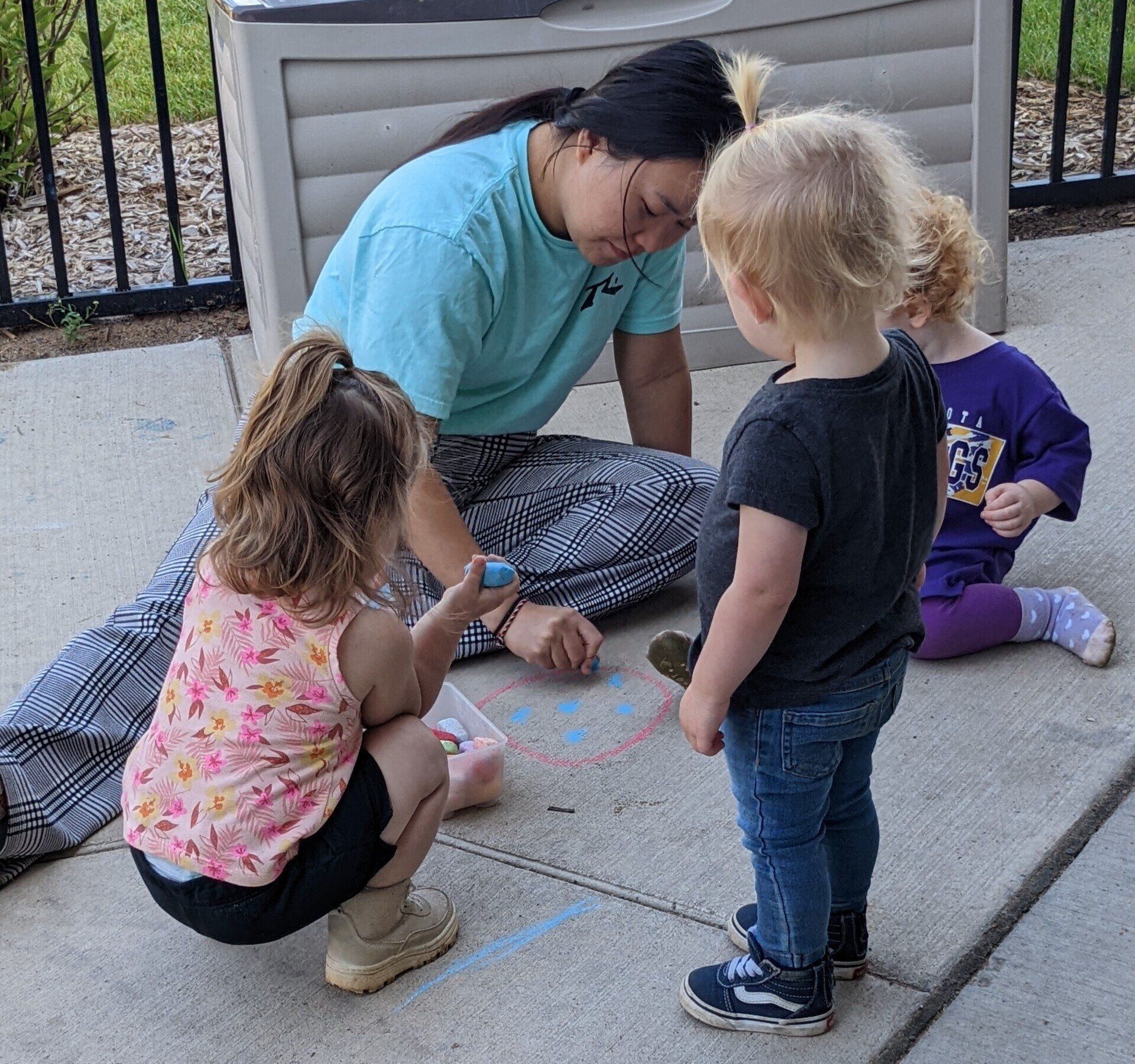 A woman playing with three children