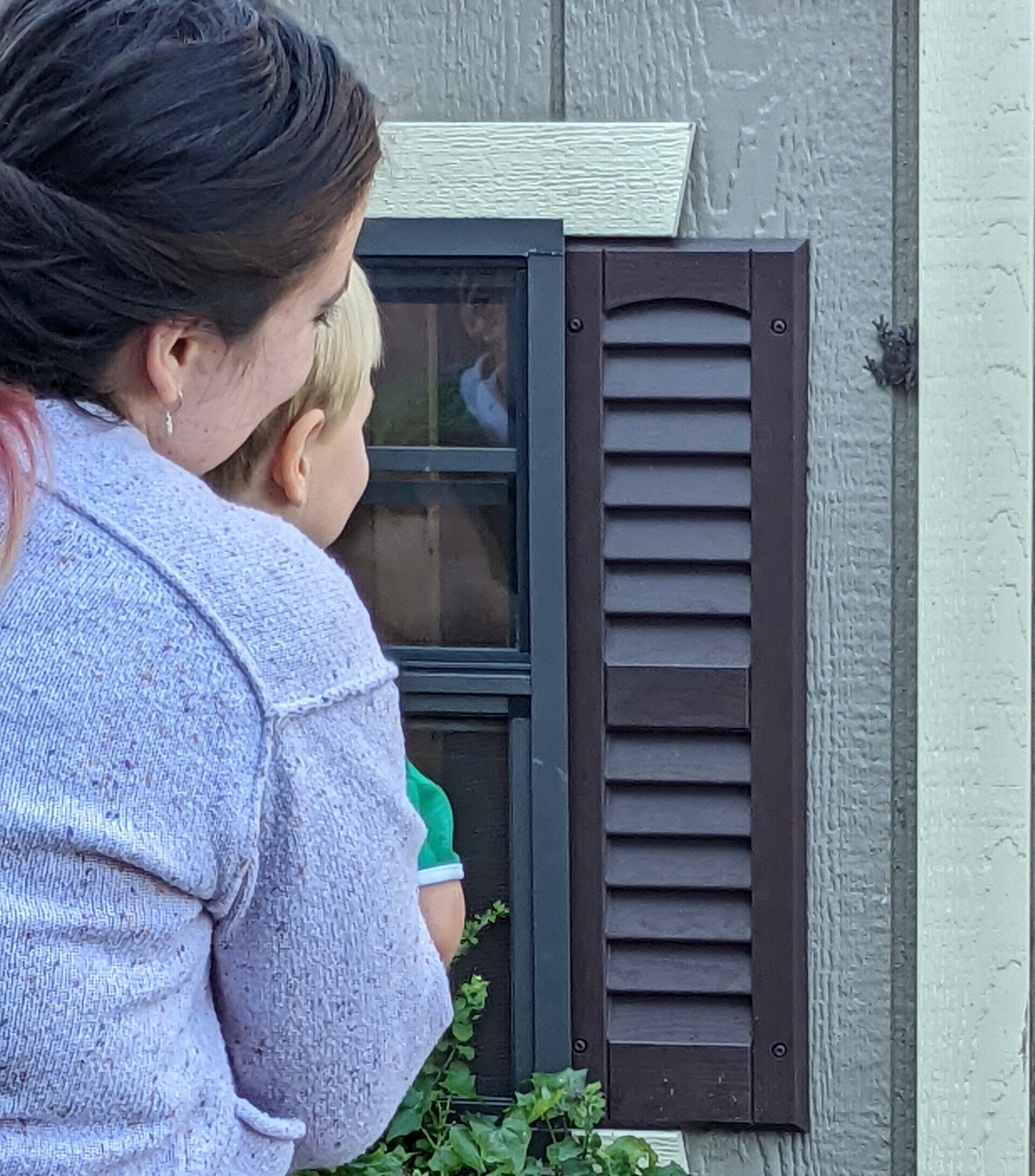 A woman and child are looking out of a window