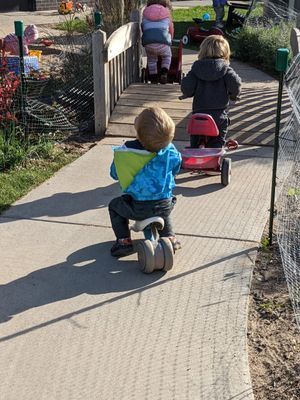 A group of children are riding tricycles 