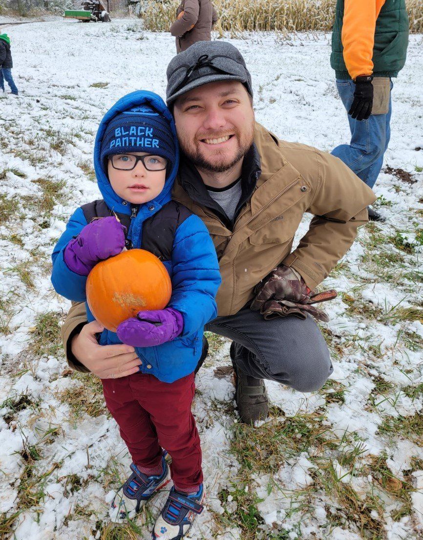 A man and a child are holding a pumpkin