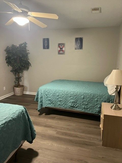 A bedroom with two beds and a ceiling fan