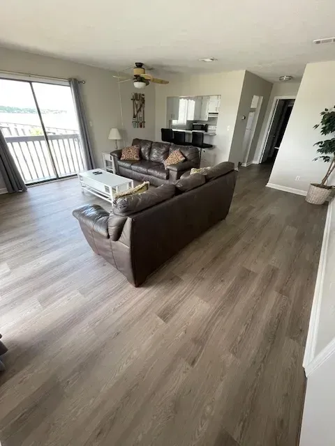 A living room with a couch , coffee table , and ceiling fan.