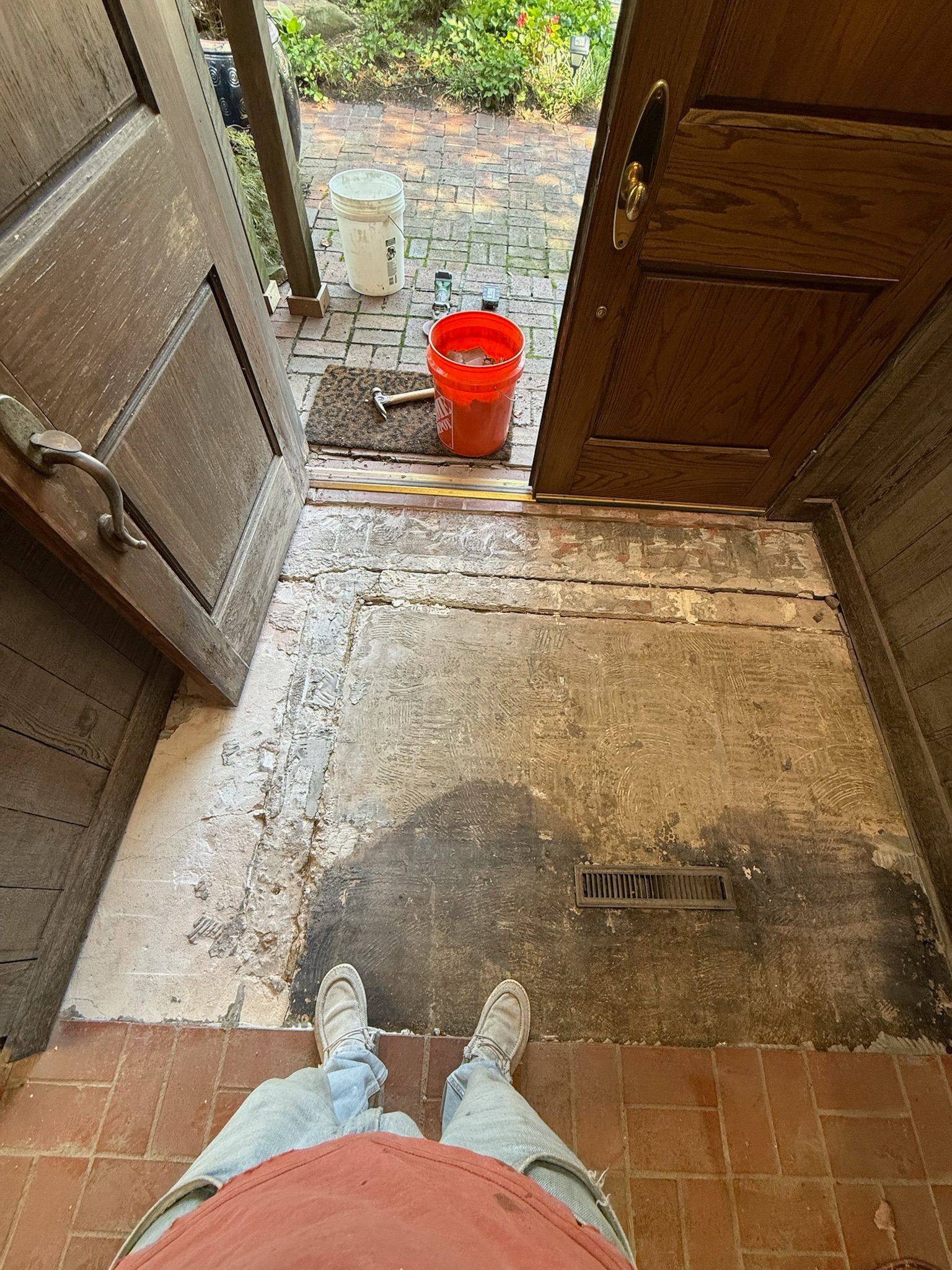 Person standing in doorway; stripping old paint off a floor.